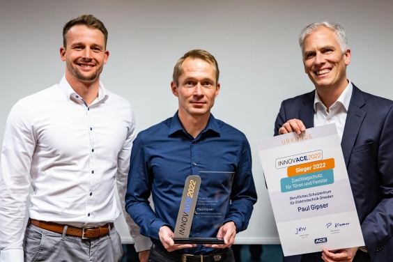 Paul Gipser vom Beruflichen Schulzentrum für Elektrotechnik Dresden, Sieger des INNOVACE 2022 der ACE Stoßdämpfer GmbH, eingerahmt von Dr. Peter Kremer (rechts), Geschäftsführer von ACE, und Toni Riediger, Marktsegment-Manager Maschinen- und Anlagenbau, bei ACE und der Stabilus Gruppe.
